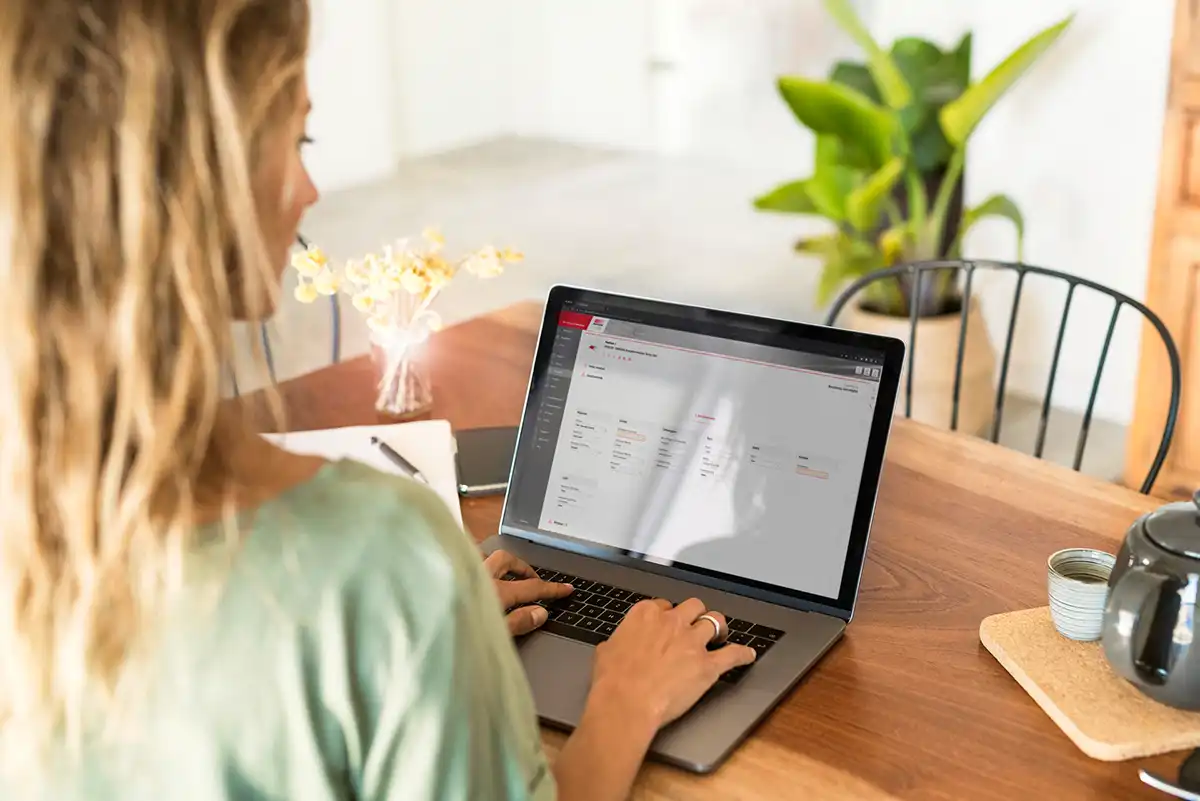 Frau arbeitet am Laptop in einem modernen Büro mit Pflanzen