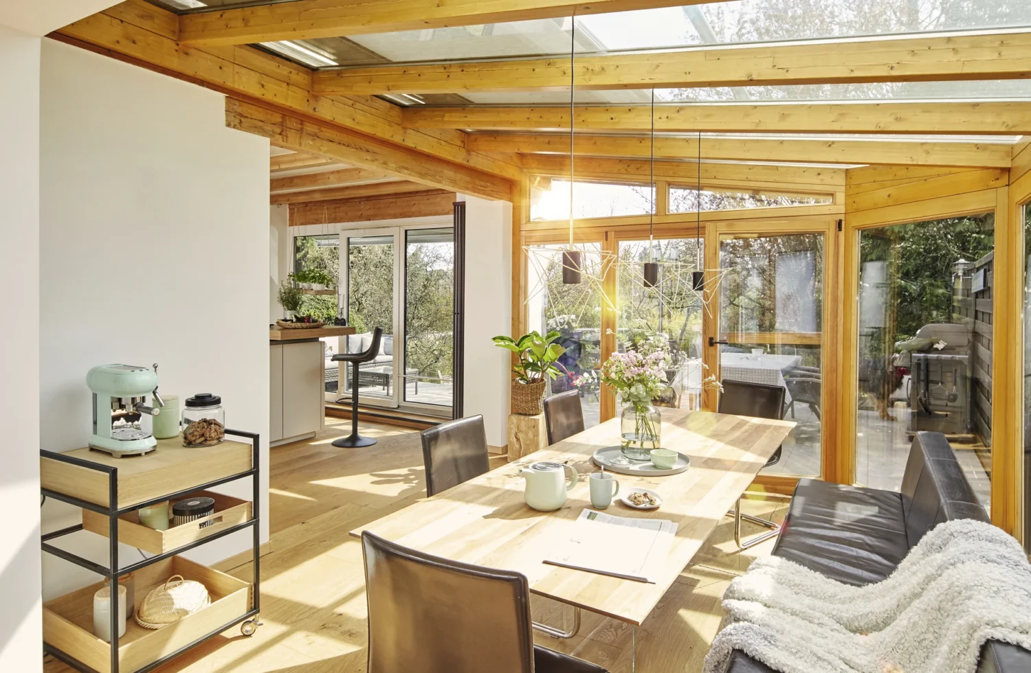 Gemütlicher Wintergarten mit Holzbalken und moderner Einrichtung