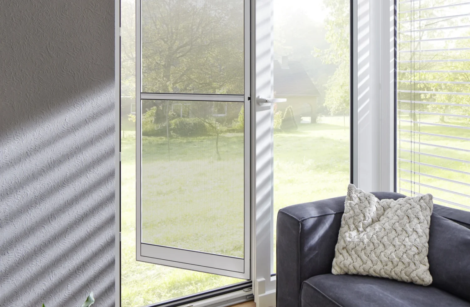 Moderne Wohnzimmereinrichtung mit offener Terrassentür und gemütlichem Sofa