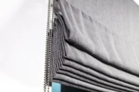 Dunkles Raffrollo mit Raffungen in Nahaufnahme mit Kugelkette