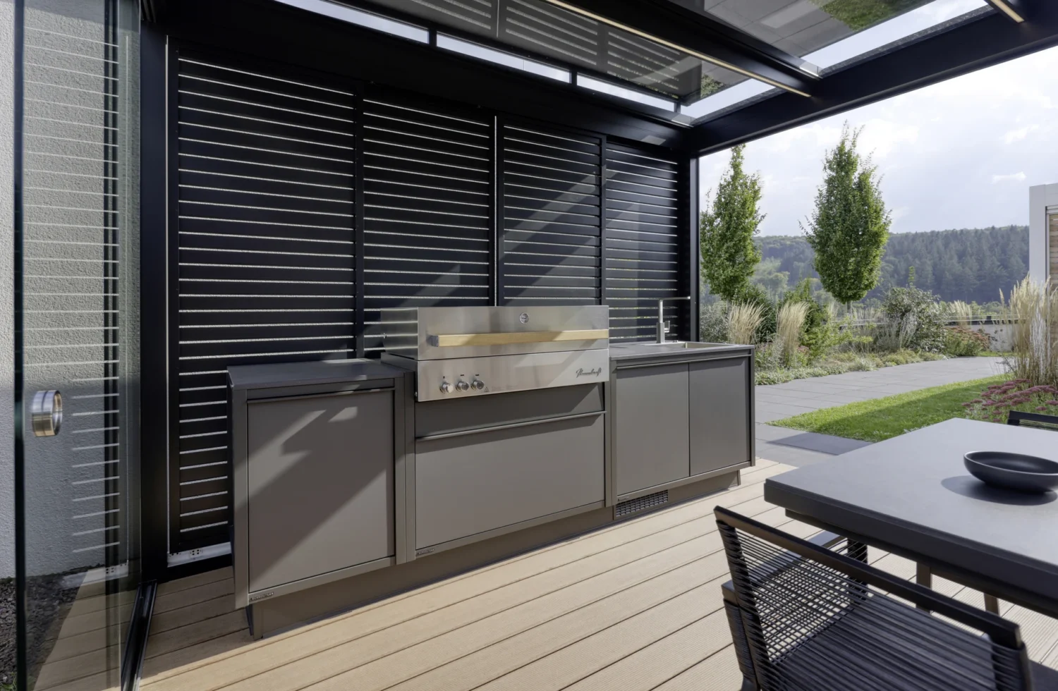 Moderne Outdoor-Küche mit Edelstahlgrill in einem stilvollen Terrassenbereich